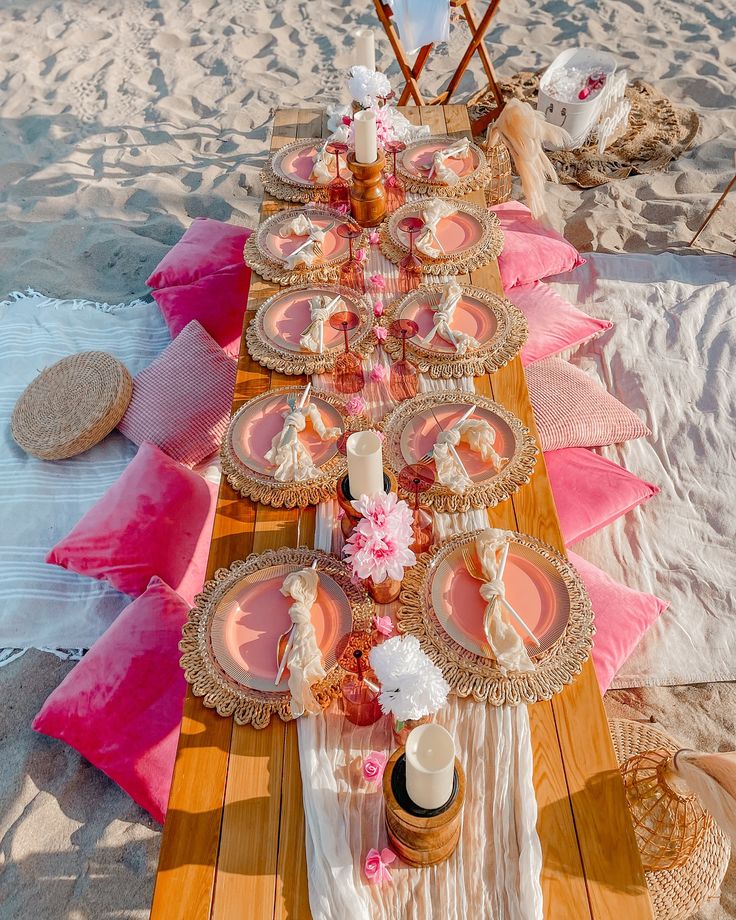 A pink beach picnic tablescape styled on the sand